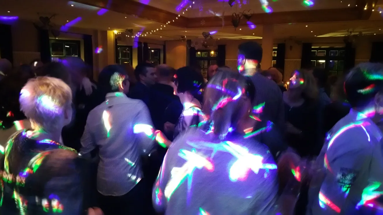 Volle Tanzfläche mit bunten Lichtpunkten