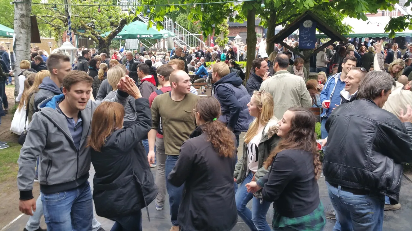 Gäste feiern beim Open-Air-Fest unter Bäumen