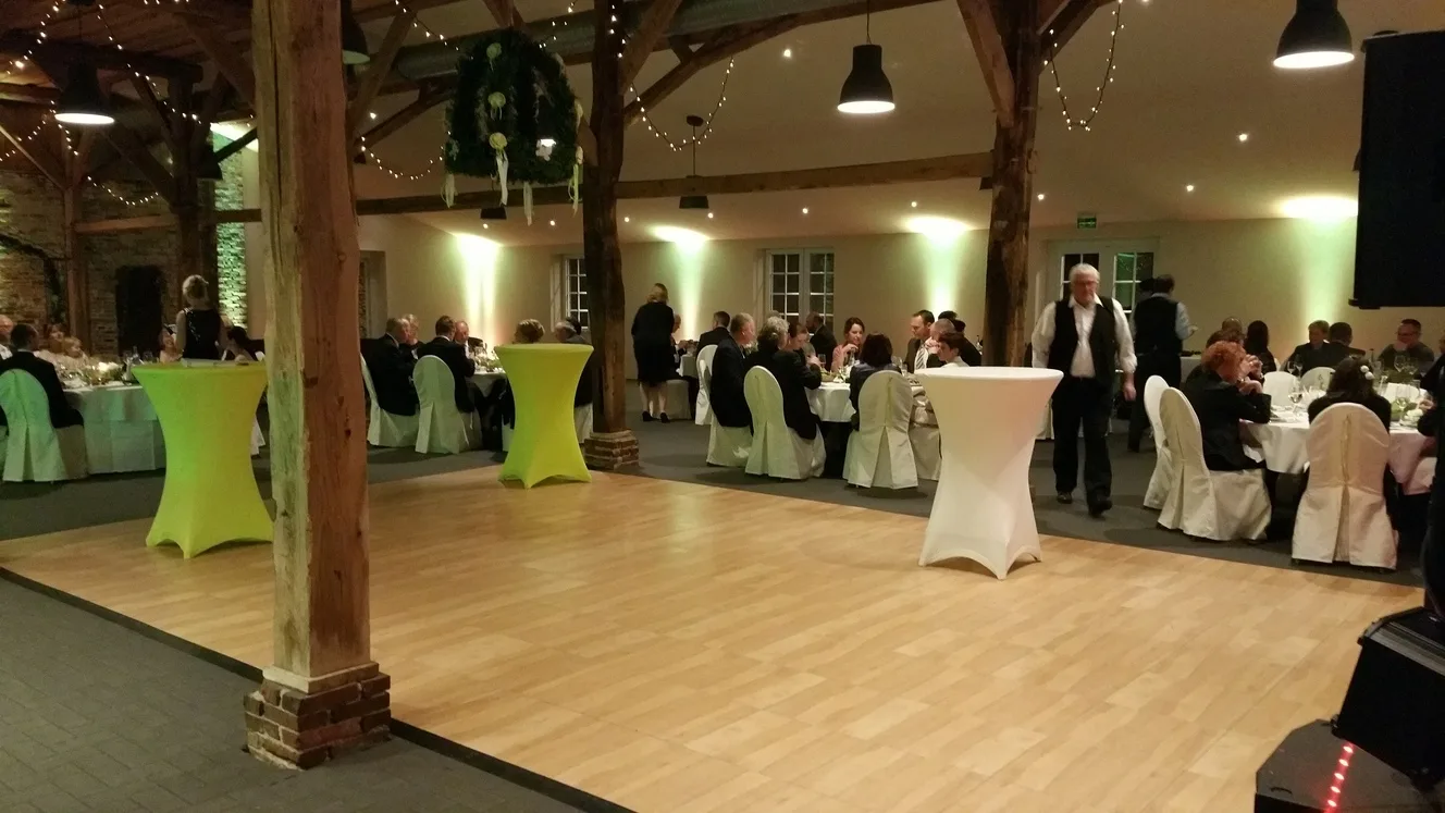 Freie Tanzfläche und gedeckte Tische in der Festscheune
