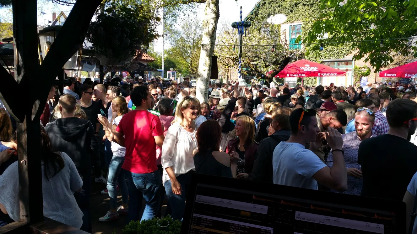 Open-Air-Fest bei Sonnenschein mit DJ-Laptop im Vordergrund