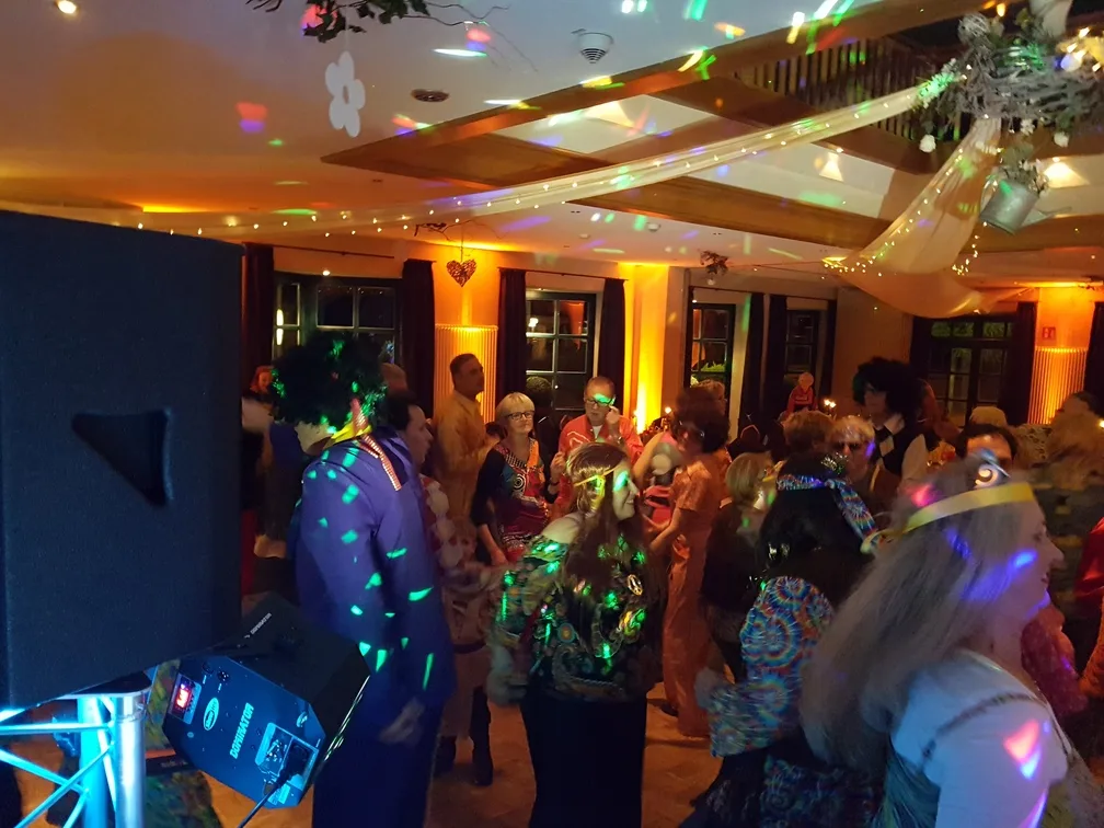 Kostümierte Gäste tanzen bei einer Motto-Party