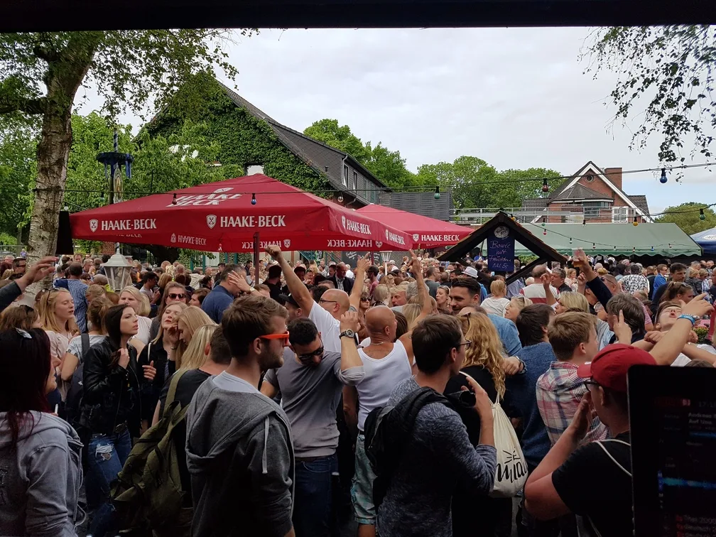 Gäste feiern beim Open-Air-Fest unter Sonnenschirmen