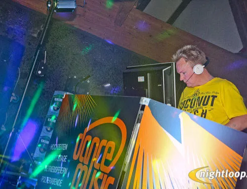DJ Axel Schmiech mit Headset am beleuchteten DJ-Pult